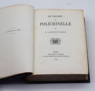 un livre ouvert posé sur une table à côté d'une table blanche
