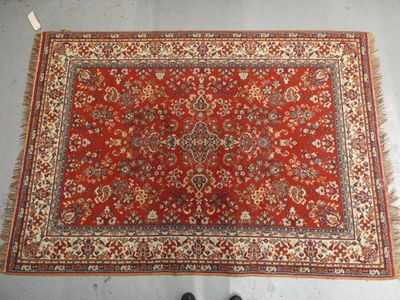 un tapis rouge posé au sol, avec une personne debout à côté