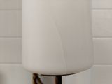 a close up of a lamp on a table in front of a white brick wall