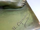 a bronze statue of a hand holding a book with writing on it