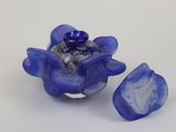 a blue glass flower with a shell inside of it