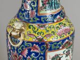 a blue vase with a gold handle on a table