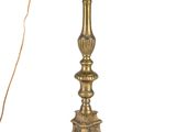 an antique brass candle holder with a candle on top of it