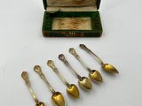 six silver spoons in a wooden box with a green lid