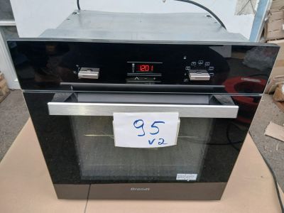 un four noir posé sur une boîte en carton sur laquelle est collée une étiquette de prix