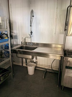 une cuisine avec un évier et une poubelle