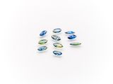 a group of blue and green glass beads on a white surface