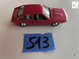 une petite voiture rouge à côté d'un morceau de feutre