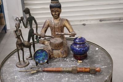 a statue of a man sitting on top of a table next to other items