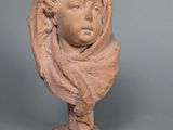 une photo d'une sculpture en argile représentant un enfant portant une écharpe