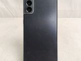 a close up of a black phone on a stand on a white surface