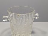 un verre en verre transparent muni d'une anse, posé sur une table