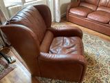 a brown leather couch and a chair in a living room