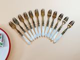 several forks and a plate with a piece of cake on it