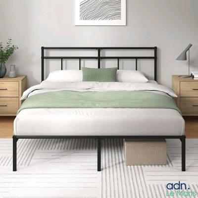 une photo d'une chambre à coucher avec un lit et deux tables de chevet