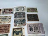 several old paper money notes are displayed on a white surface