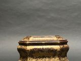 an antique bronze box with a lid on a gray background