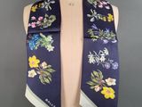 a woman ' s scarf with flowers on it on a mannequin