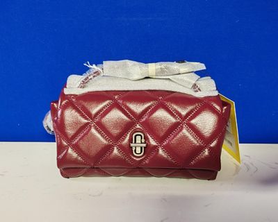 red quilted purse with a bow on top of it on a table