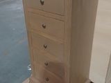 a wooden chest of drawers on a pallet in a warehouse