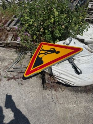 un panneau jaune et rouge posé par terre