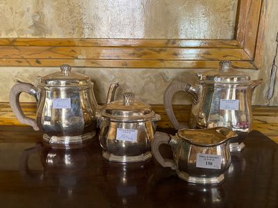 three silver teapots sitting on a table next to a mirror