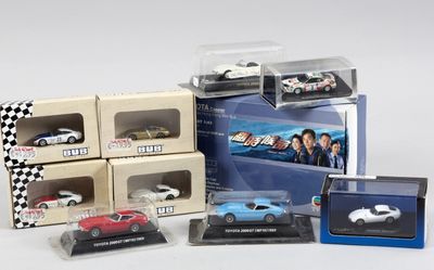 six modèles différents de voitures dans des boîtes, posées sur une surface blanche