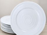 quatre assiettes blanches empilées les unes sur les autres sur une table en bois