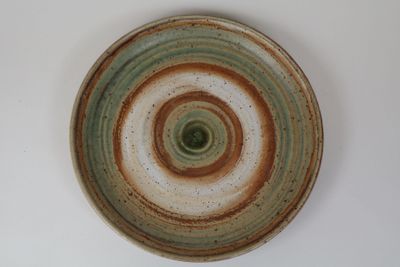 une assiette marron et verte posée sur une table blanche