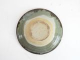 a green and white plate on a white table