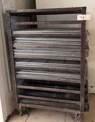 une pile de plaques métalliques posée sur un chariot dans une pièce
