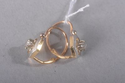 a gold ring with a diamond on it on a white surface