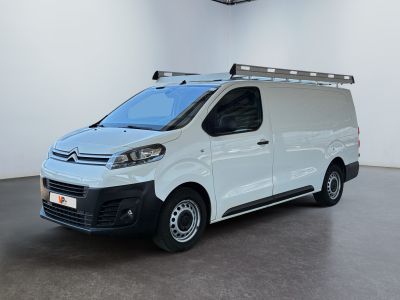 La camionnette blanche est garée dans une grande pièce où la lumière est allumée.