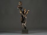 bronze sculpture of a woman holding a bird on a pedestal