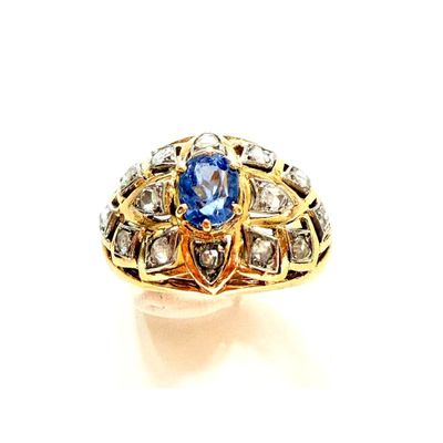 gros plan d'une bague avec une pierre bleue entourée de diamants