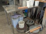 many buckets and pans sitting on a table in a garage