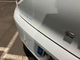 a close up of a white car parked in a parking lot