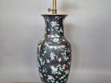 une image représentant un vase noir et rose avec un socle doré