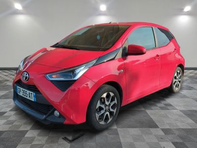 une Toyota Yaris rouge garée sur un sol à damier