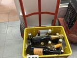 bottles of wine are in a yellow basket on the floor