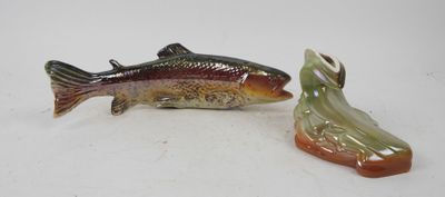 two figurines of a fish and a shoe on a white surface