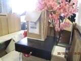 a black table with a box on top of it and a pink flower in a vase