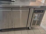 a stainless steel kitchen island with a microwave on top of it