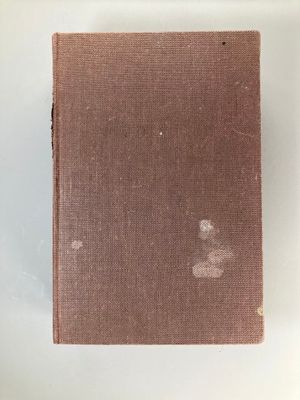 un vieux livre posé sur une table blanche