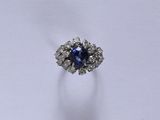 gros plan d'une bague avec une pierre bleue entourée de diamants blancs