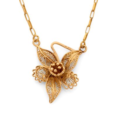 un gros plan d'un collier en or orné d'une fleur