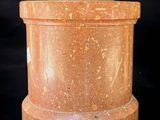 a close up of a stone container with a lid on a black background