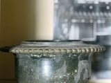 un pot posé sur une étagère devant une horloge