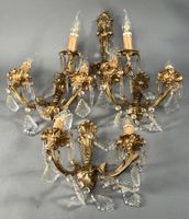 Quatre APPLIQUES en bronze ciselé doré à décor de volutes et…