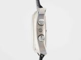 the back of a silver watch with a black leather strap